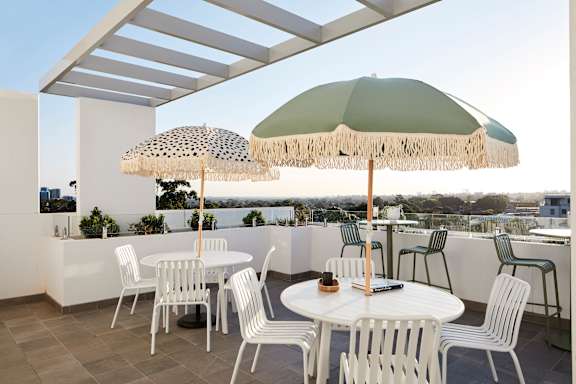 a terrace with tables and umbrellas on a roof