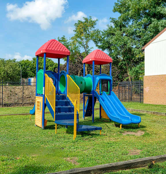 a playground with two slides in a yard