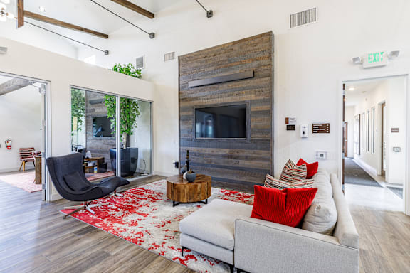 A living room with a white couch and a wooden wall.