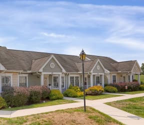 a home with a porch and a street light in front of a grassy field