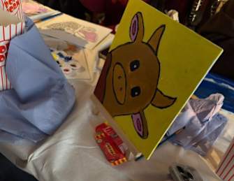 A yellow cardboard box with a drawing of a pig on it.