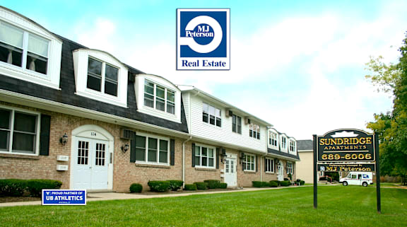 A row of houses with a sign for MJ Peterson Real Estate in the background.