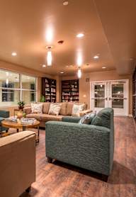 A living room with a couch, a table, and a potted plant.