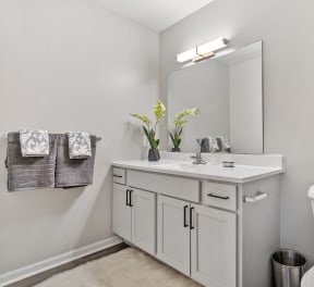 a white bathroom with a toilet sink and mirror