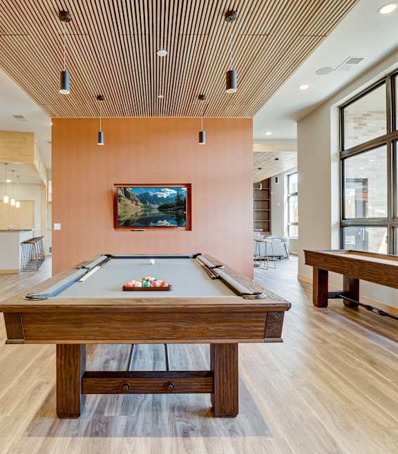 a lounge area with tables and chairs and a privacy screen