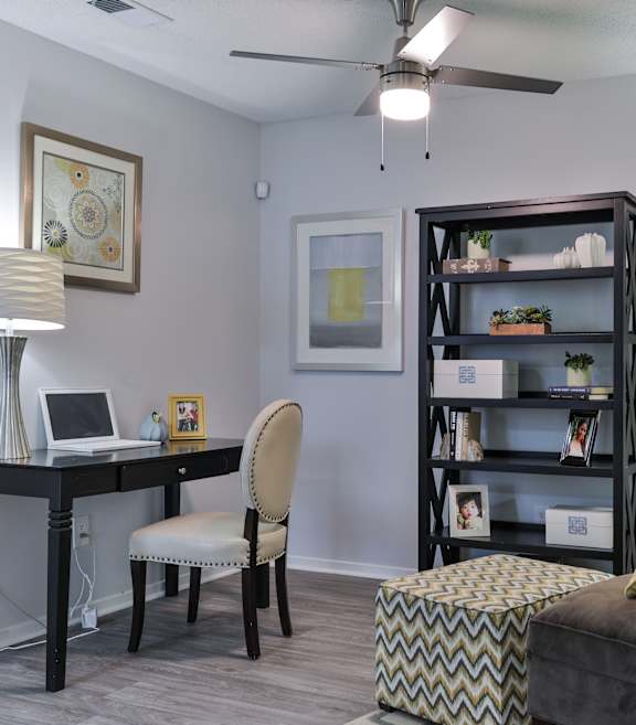 A room with a desk, chair, and bookshelf.