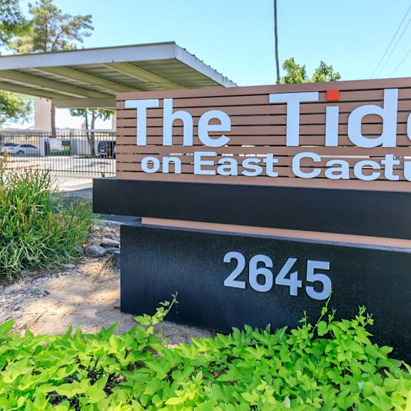 A sign that says "The Tides on East Cactus" with a number 2645 on it.