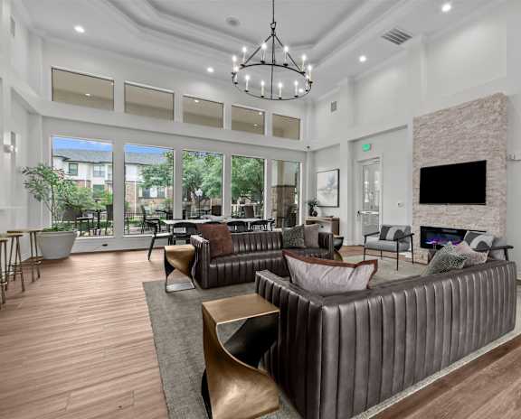 A room with a ceiling fan and a kitchenette in the background.
