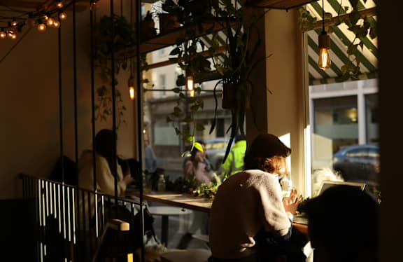 A person is sitting at a table in a dimly lit restaurant.
