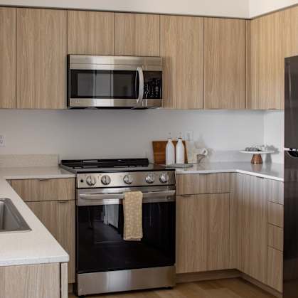 A modern kitchen with wooden cabinets and stainless steel appliances.