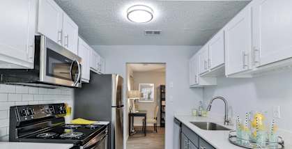 A kitchen with a black stove top oven and a black microwave.