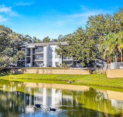 a building overlooking a body of water with trees