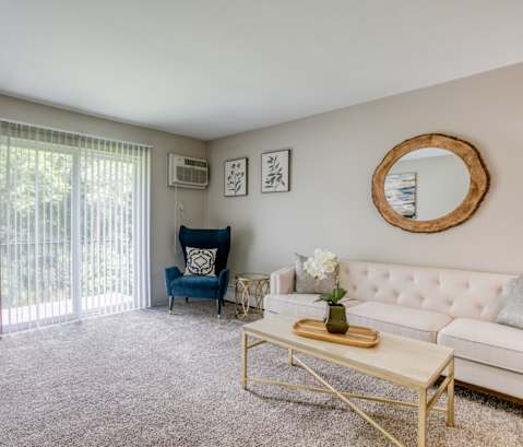 a living room with a sliding glass door leading to a balcony