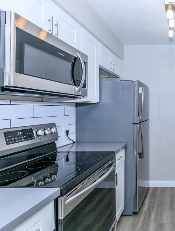 a kitchen with stainless steel appliances and white cabinets at Tides at Mesa, Mesa, AZ, 85204