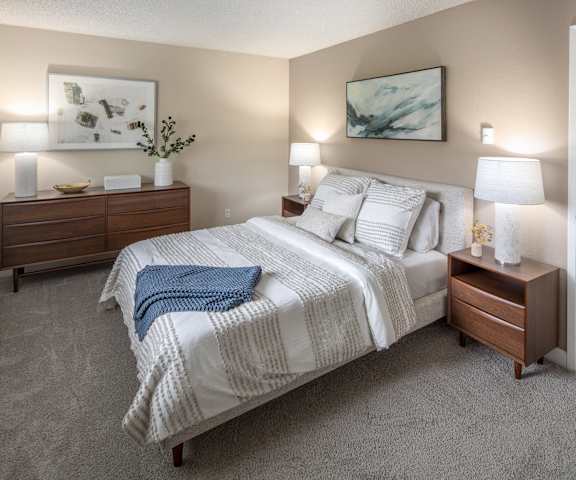 a bedroom with a bed and two nightstands and a closet