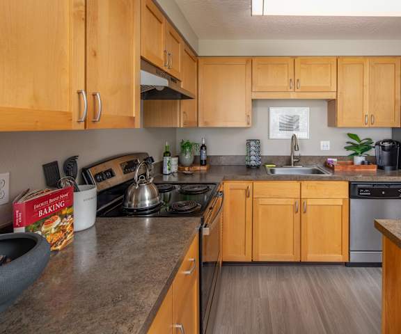 A kitchen with wooden cabinets and a black stove top.