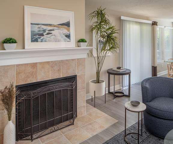 A living room with a fireplace and a painting on the wall.