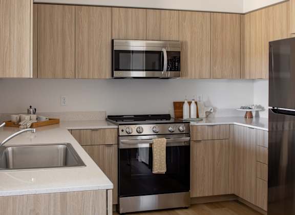A modern kitchen with wooden cabinets and stainless steel appliances.
