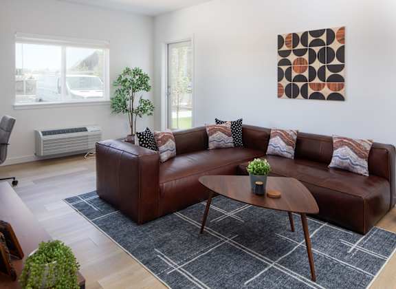 A brown leather couch with a small potted plant on it.