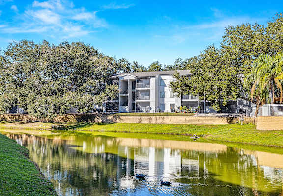 a building overlooking a body of water with trees