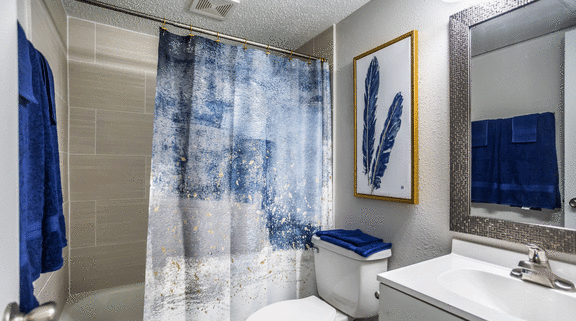 a bathroom with a shower curtain and a toilet and a sink at Azure Place Apartments, Memphis, Tennessee