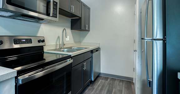 a kitchen with stainless steel appliances and black and white cabinets