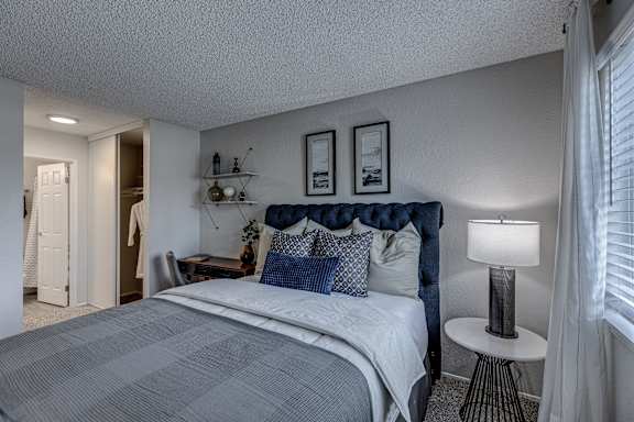 a bedroom with a bed and a nightstand with a lamp
