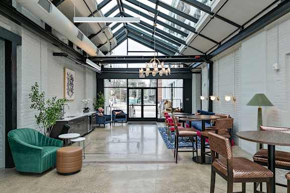 A modern cafe with a glass ceiling and wooden furniture.