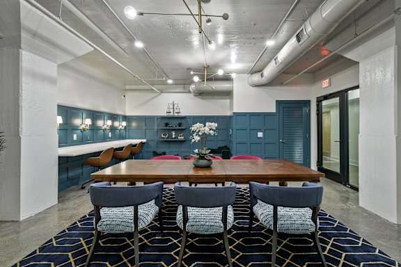 A dining room with a wooden table and chairs.