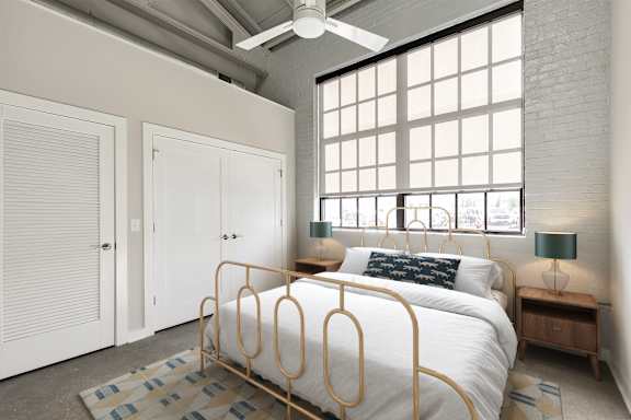 A bedroom with a bed, a ceiling fan, and a window with blinds.