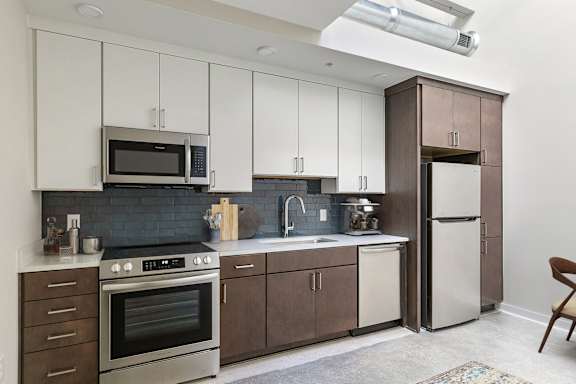 A kitchen with white cabinets and a black stove top oven.