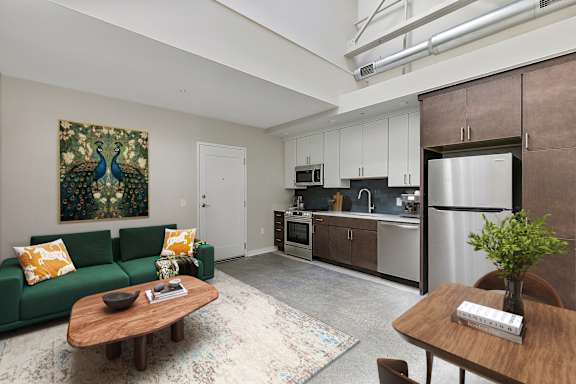 A living room with a green couch and a wooden coffee table.