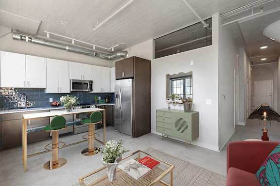 A modern kitchen with a red chair and a wooden table.