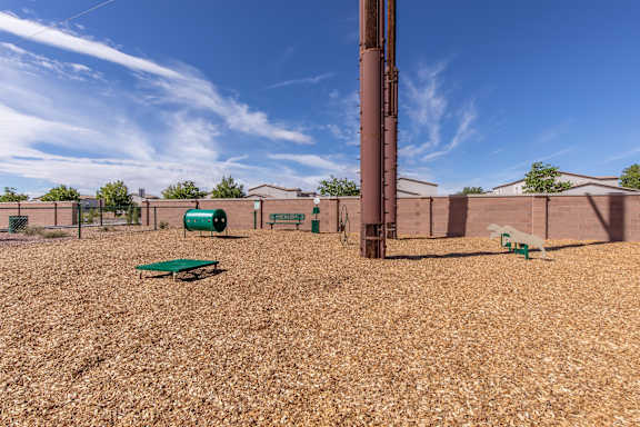 A playground with a green slide and a brown pole.