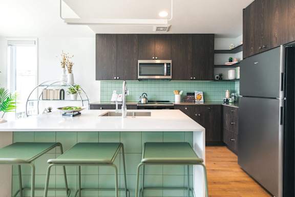 a kitchen with an island and three green stools