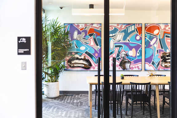 a room with tables and chairs and a mural on the wall