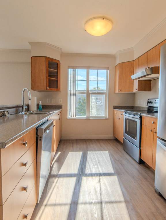 A kitchen with a refrigerator on the right side.