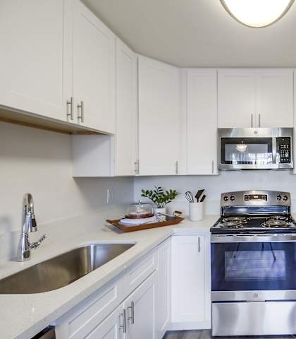 a kitchen with white cabinets and stainless steel appliances