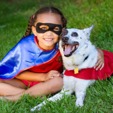 a girl in a superhero costume with her dog