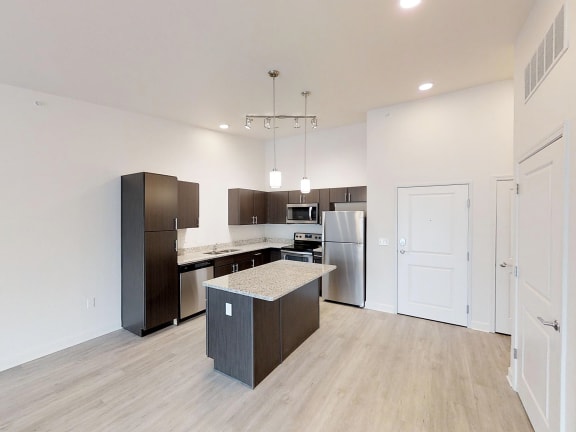 a renovated kitchen with stainless steel appliances and wood flooring