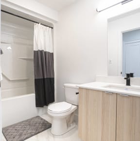 a bathroom with a toilet and a sink and a shower