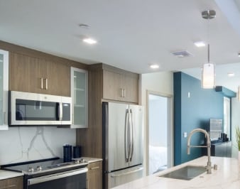 a kitchen with a large island and a dining room with a table and chairs