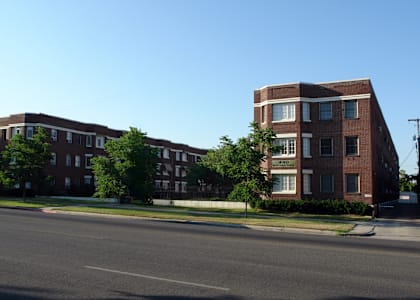 A street view of a residential area with apartment buildings.