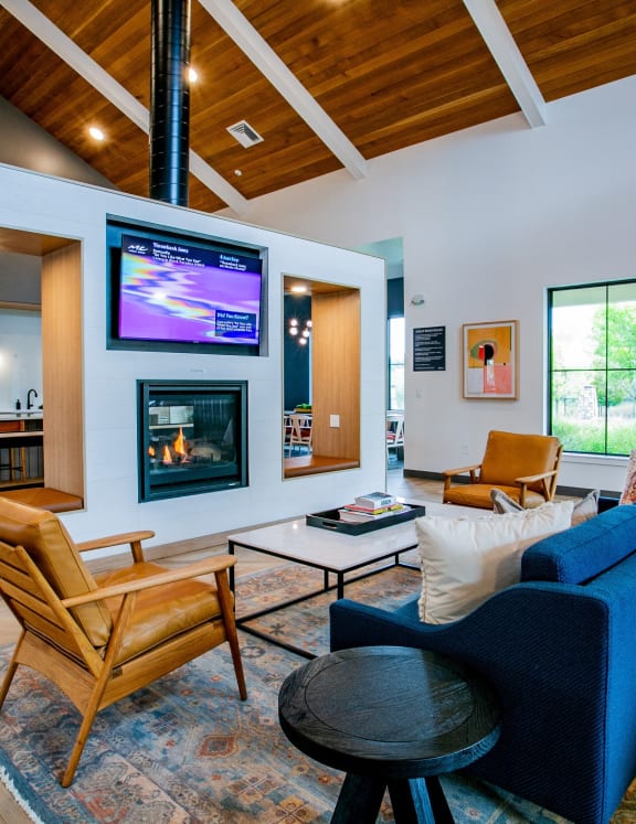 a living room with a blue couch and chairs and a fireplace