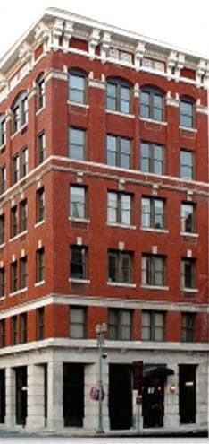 a tall red brick building on a city street