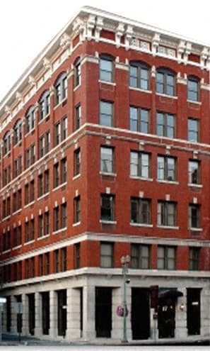 a tall red brick building on a city street