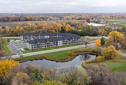 an aerial view of a building next to a pond