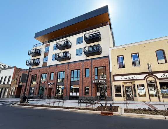 A modern building with balconies on the upper floor.