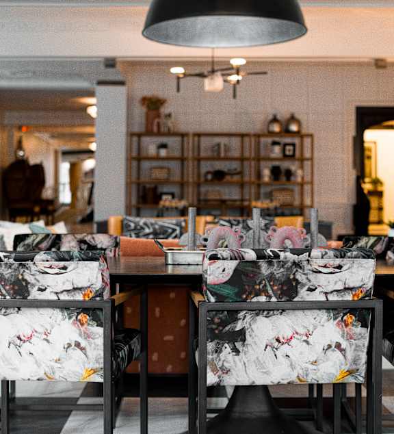 A dining room with a table and chairs with a floral pattern.