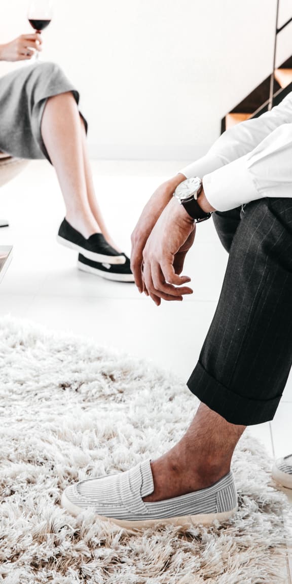 two people sitting in a living room holding hands
